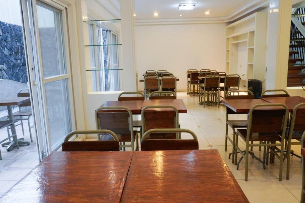 una clase con mesas y sillas en una habitación en Makati Altean Apartment (Maura Room) en Manila