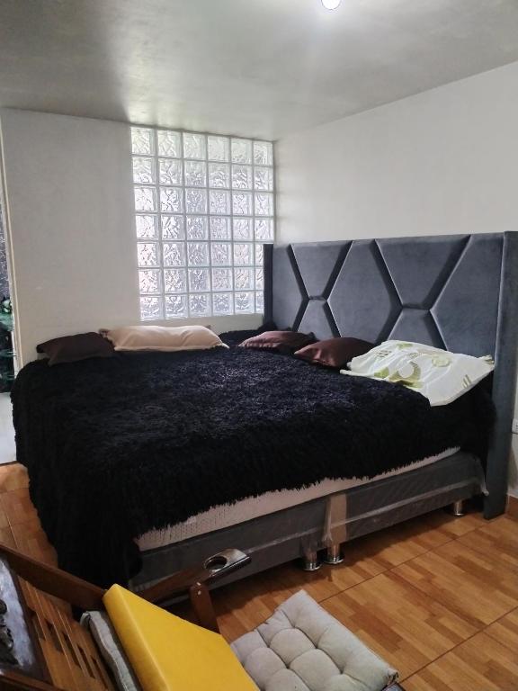 duże czarne łóżko w pokoju z oknem w obiekcie Habitación con jacuzzi y amoblado w mieście Huancayo