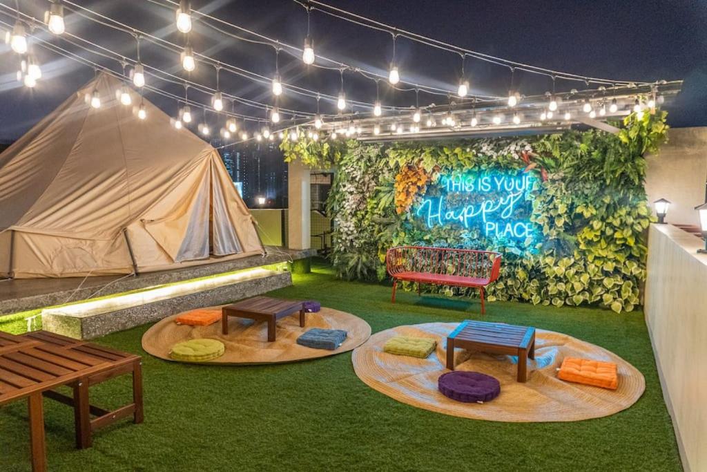 a room with a tent and tables and a bench at Maria Deck Urban Glamping in Manila