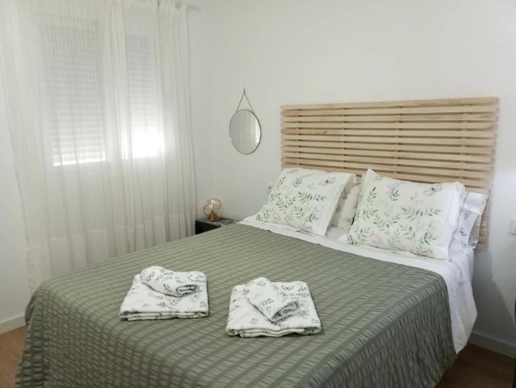 a bedroom with a bed with two towels on it at Apartamento Turístico Damajuana in Espartinas