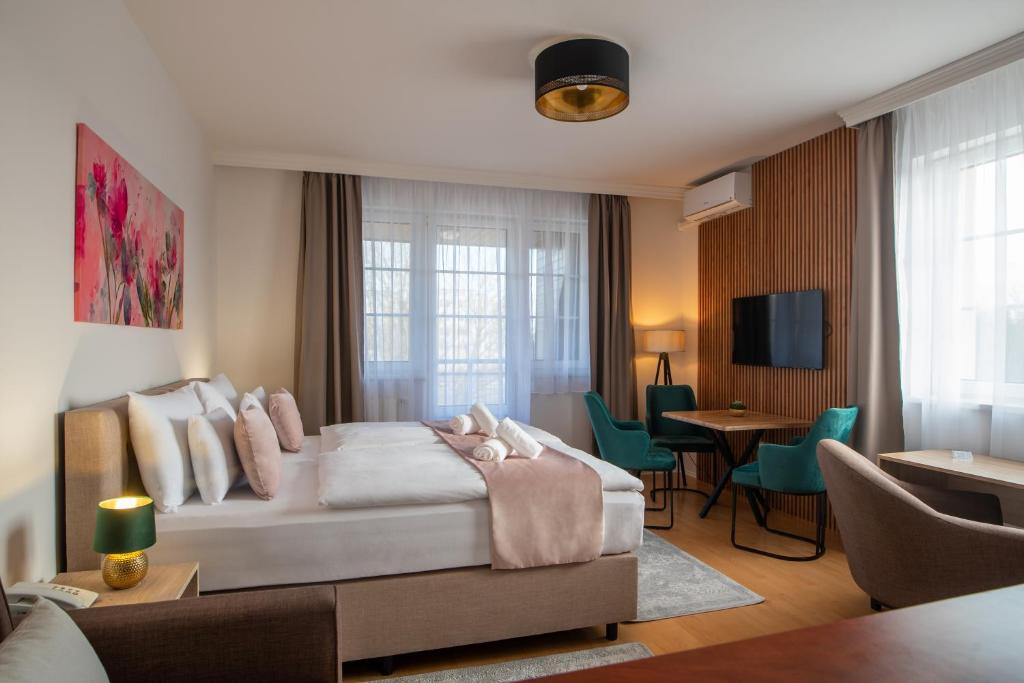 1 dormitorio con 1 cama y sala de estar en Holdvirág Hotel, en Sárvár