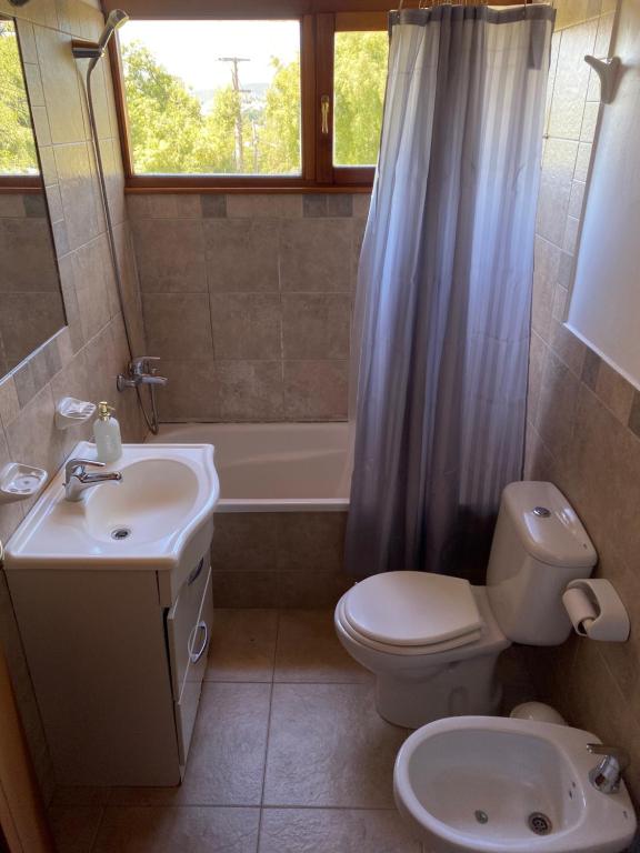 ein Badezimmer mit einem Waschbecken, einem WC und einer Badewanne in der Unterkunft Hermosa Casa Familar de Montaña in San Carlos de Bariloche