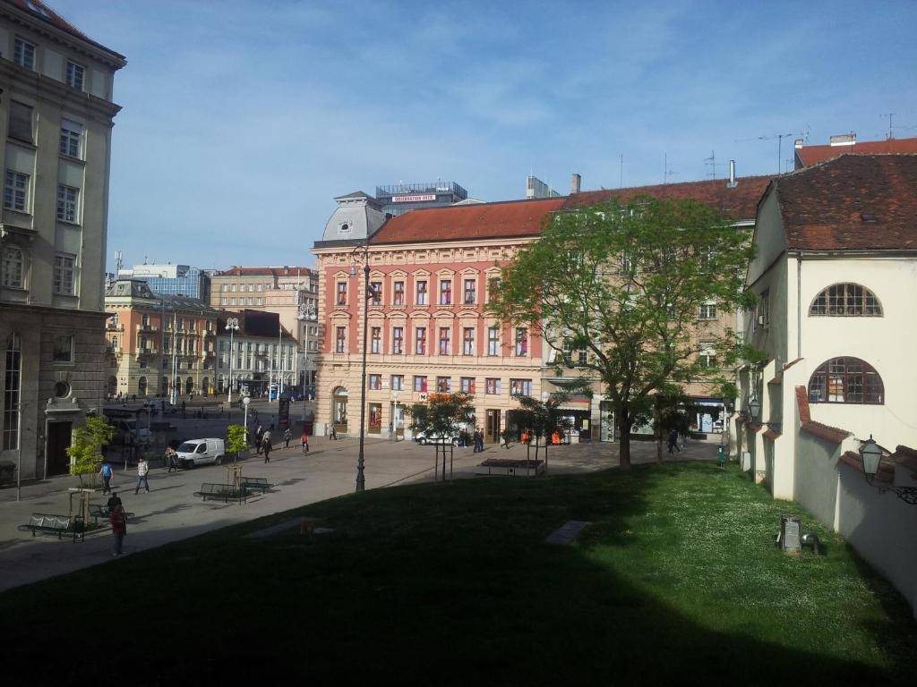 a large brick building with a green lawn in a city at Apartment History in Zagreb