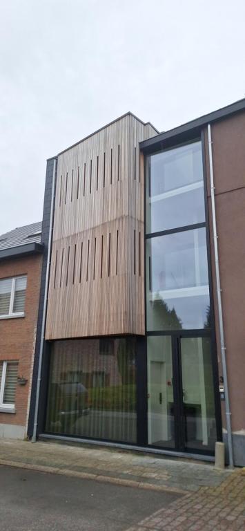 een gebouw met grote glazen ramen aan de zijkant bij Den Ommegang in Halle