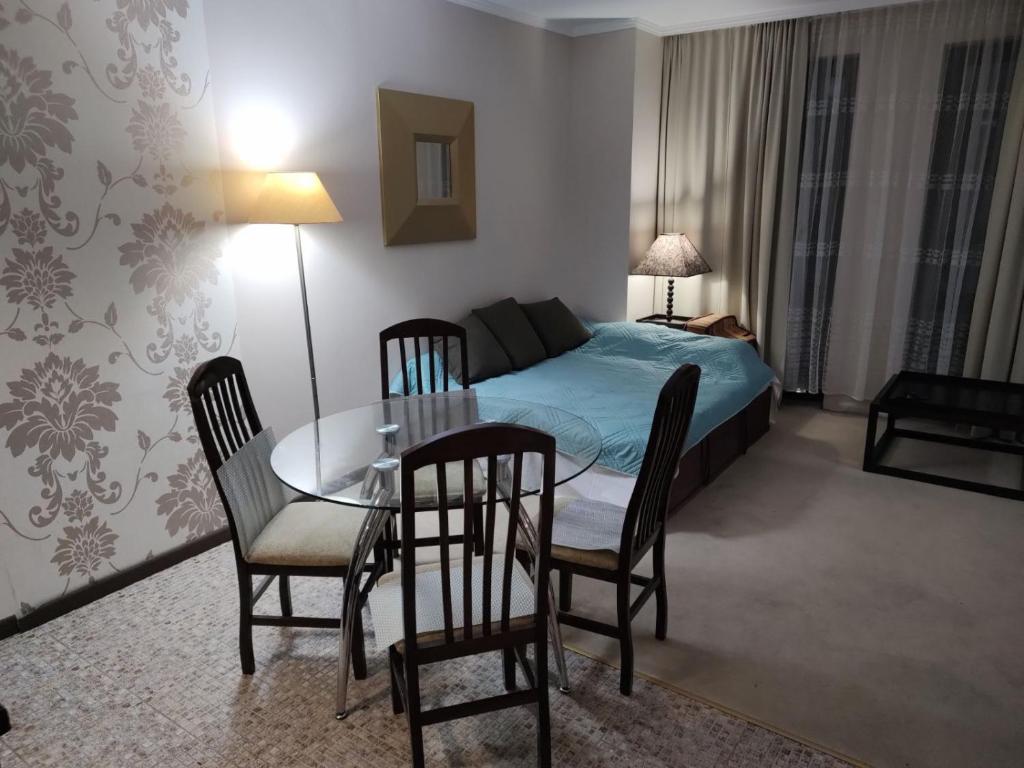 Schlafzimmer mit einem Bett, einem Tisch und Stühlen in der Unterkunft Arendo Sea апартамент в Barceló in Sonnenstrand