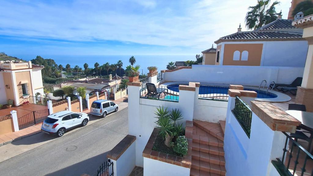a white house with a car parked on the street at Nerja Villas Tamango Hill 5 Silhouse in Torrox