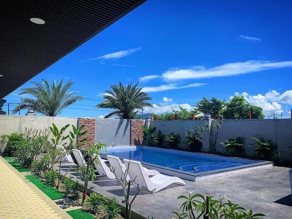 een zwembad in een achtertuin met een hek en palmbomen bij 雲上 Villa in Hengchun