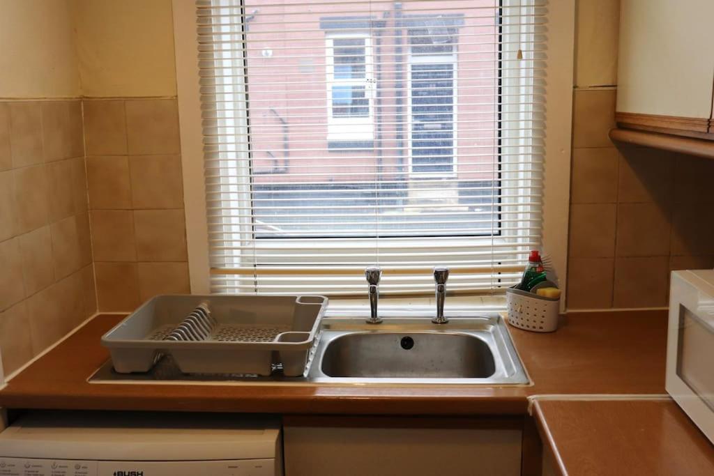 a sink in a kitchen with a window at Comfortable 2 Bedroom House in Beeston Hill