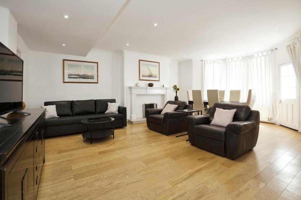 sala de estar con 2 sofás y chimenea en Lovely South Kensington Flat en Londres