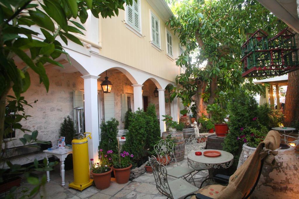 雷夫卡達鎮的住宿－艾格利酒店，户外庭院配有桌椅和植物。