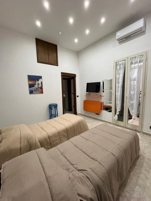 2 camas en una habitación con TV y una habitación en Barbi’s House, en Nápoles