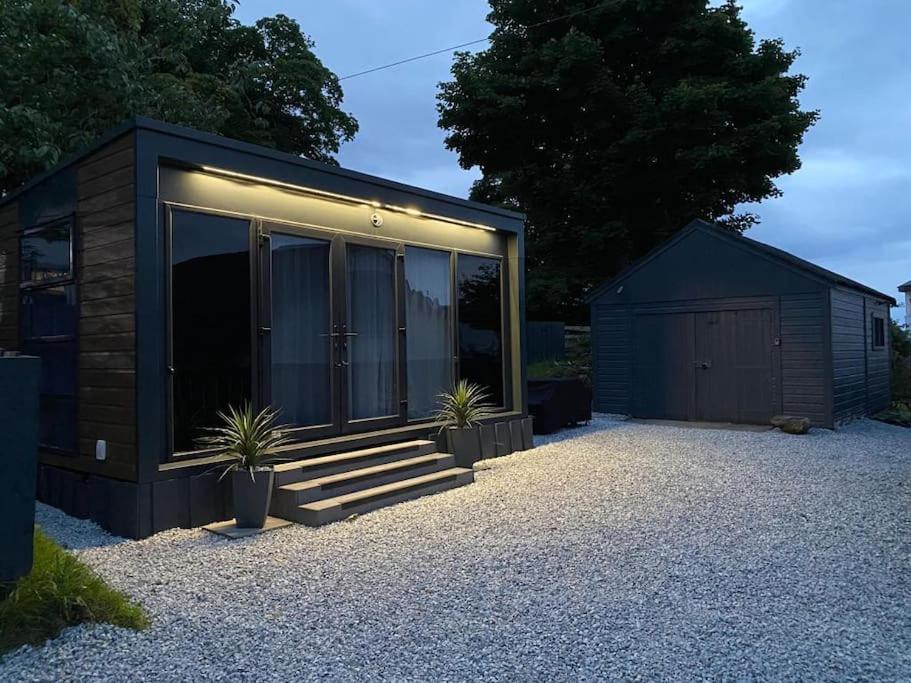 una pequeña casa con algunas plantas delante de ella en Neptunes Pod, en Fort William