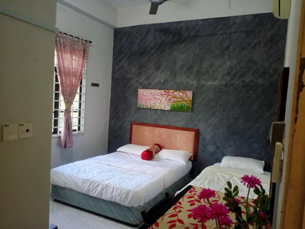 a bedroom with two beds and a window at D' BUNGA HOTEL BUKIT BUNGA Bilik Standard Triple in Batu Karang
