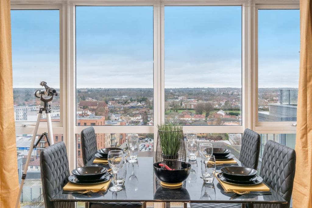 a dining room with a table and chairs and windows at LUX CONDO for 5 Slough Elizabeth line free parking in Slough