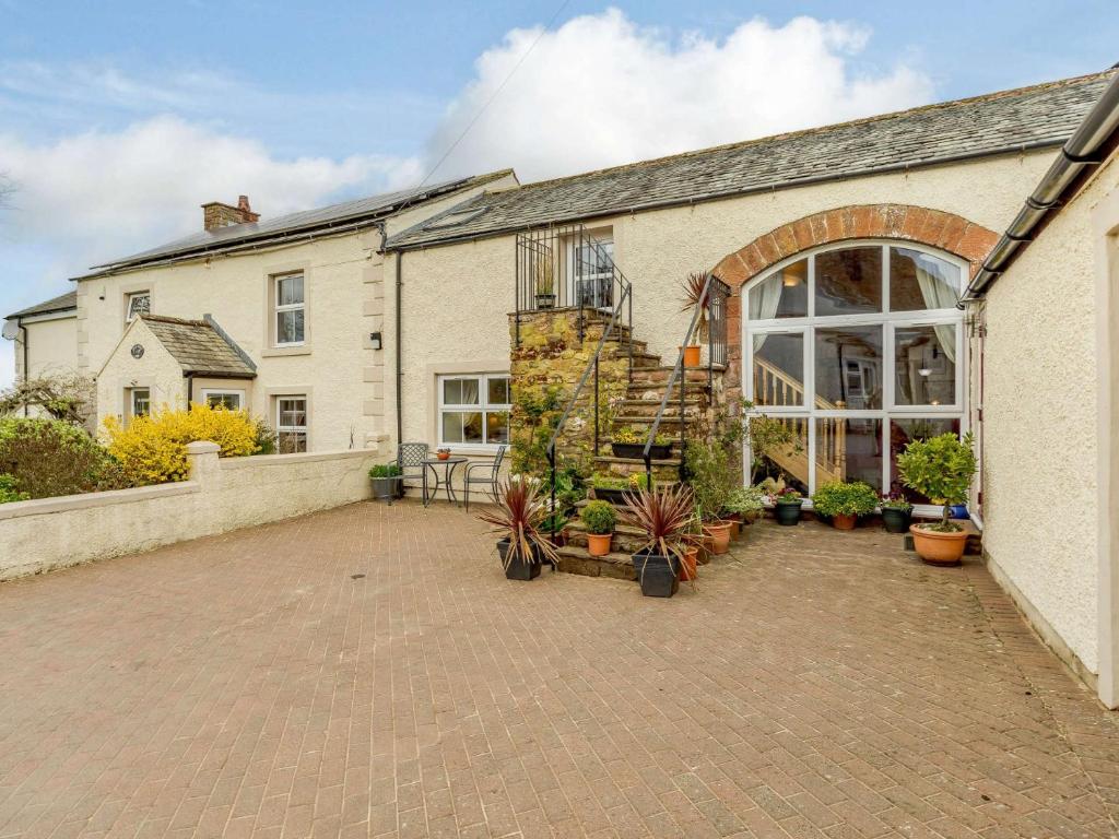 a building with a patio with potted plants on it at 2 bed in Appleby 87537 in Long Marton