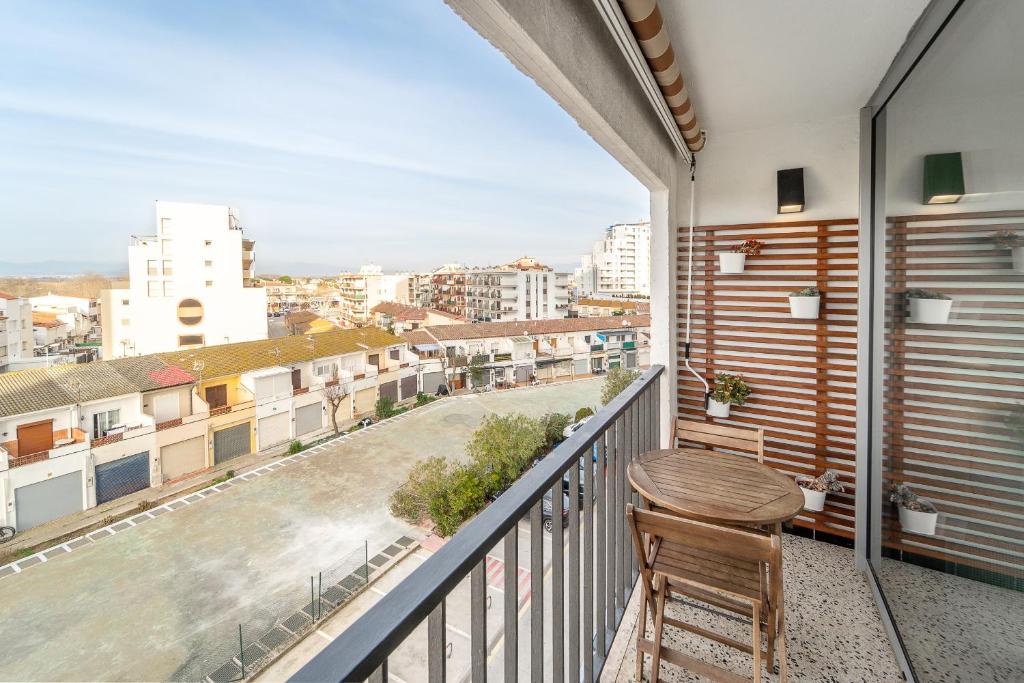 a balcony with a wooden table and a view of a city at WELCS ESTUDIO 120 EMP cerca del mar in Empuriabrava
