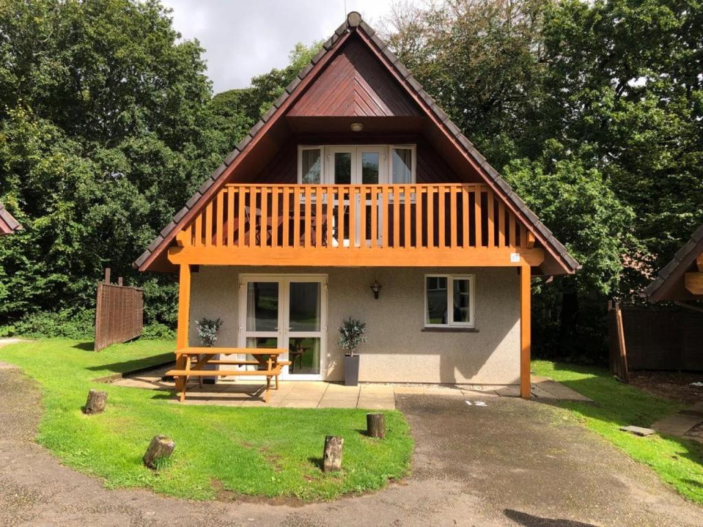 a small house with a picnic table in front of it at Hideaway Lodge Hengar Manor 4 bed sleeps 8 to10 in Michaelstow