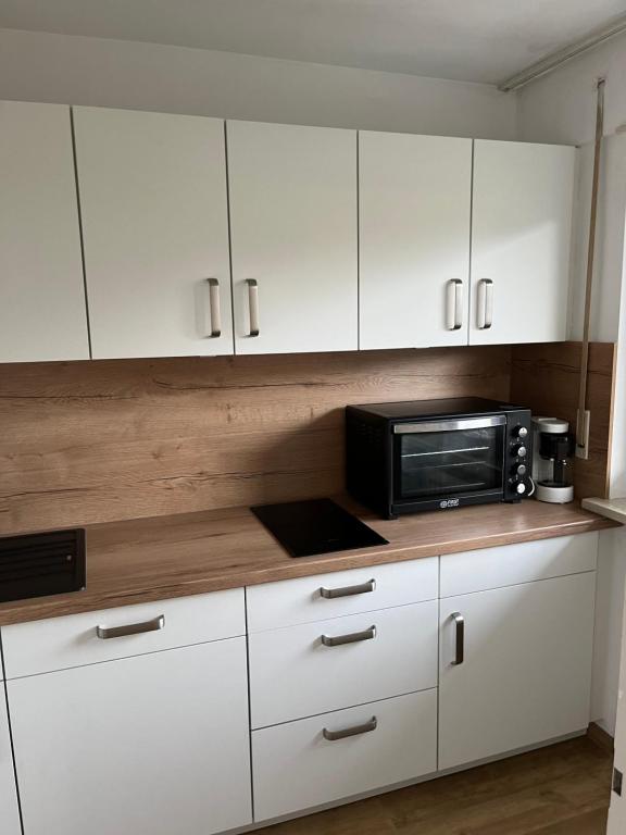 Una cocina con gabinetes blancos y un microondas. en Ferienwohnung in Oberstdorf mit wundervollem Bergpanorama, en Oberstdorf