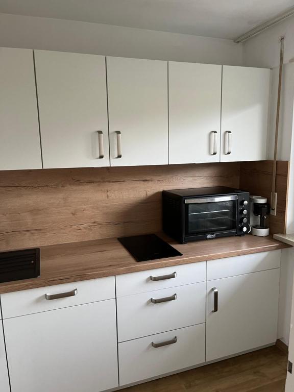 a kitchen with white cabinets and a microwave at Ferienwohnung in Oberstdorf mit wundervollem Bergpanorama in Oberstdorf