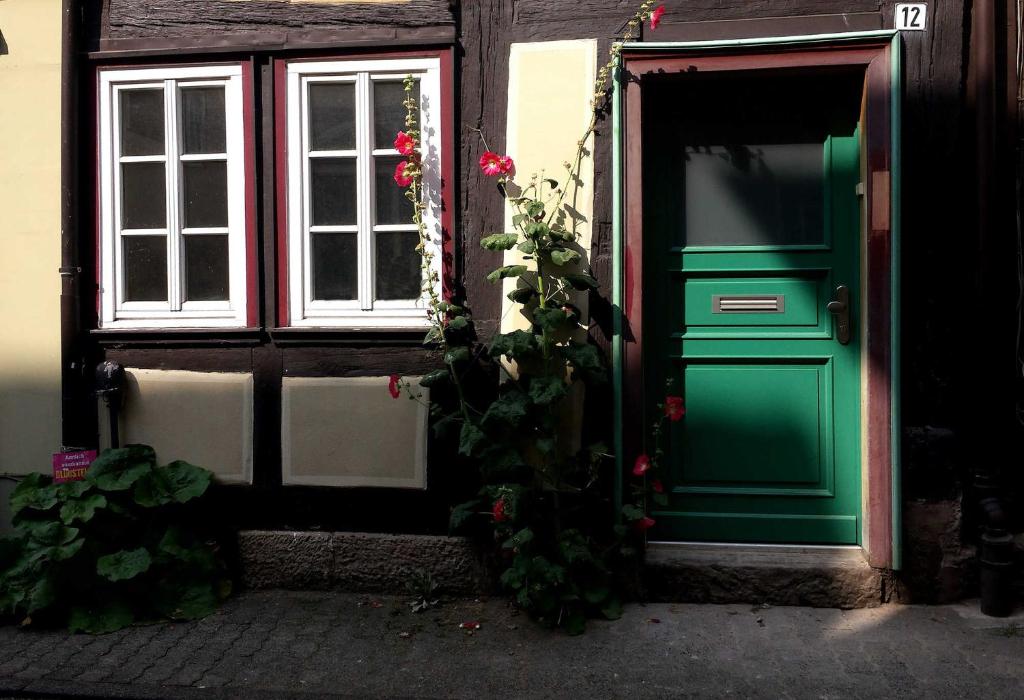 uma porta verde de um edifício com rosas em Ferienhaus Ferienwohnung Radbrunnenhaus em Hannoversch Münden