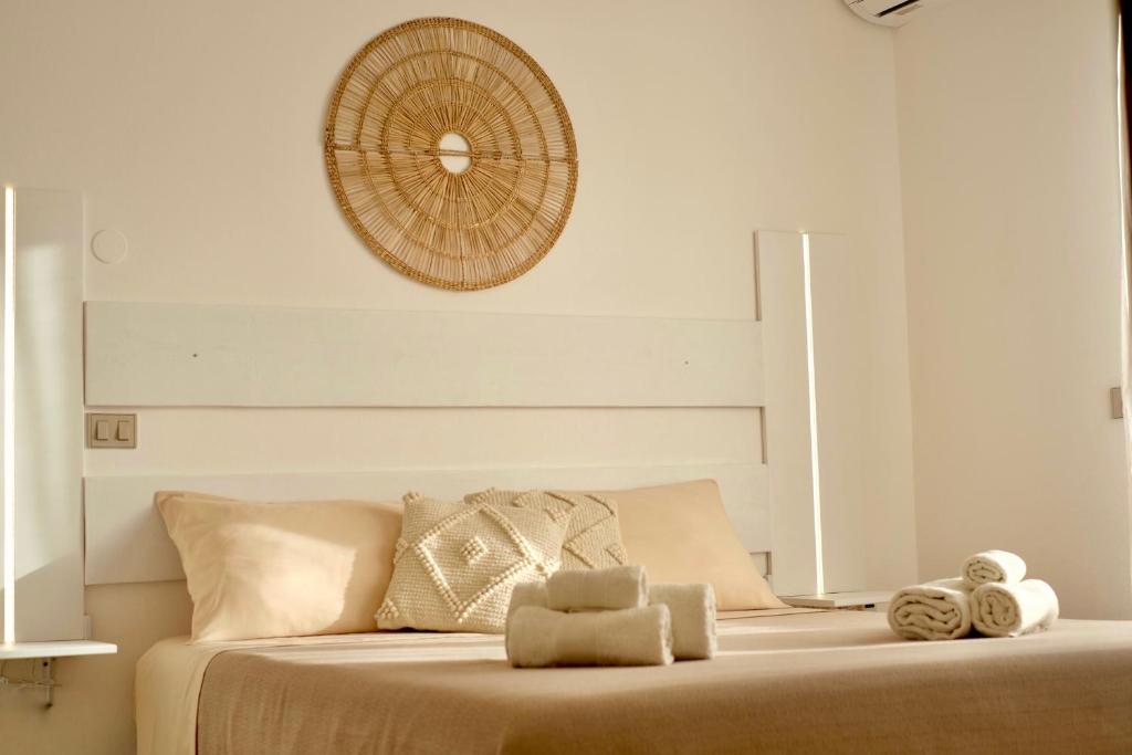 a white bedroom with a large bed with a wickerigunigunigun at Darrere del port in Alghero