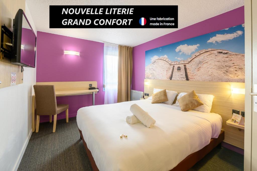 Una habitación de hotel con una cama grande y un escritorio. en BRIT HOTEL Confort CAMBRAI, en Cambrai