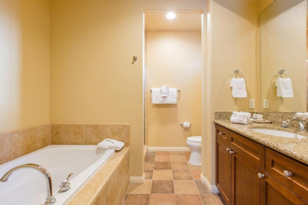un bagno con vasca, lavandino e WC di Legacy Villas Resort Luxury Next to Paseo Fountain a La Quinta