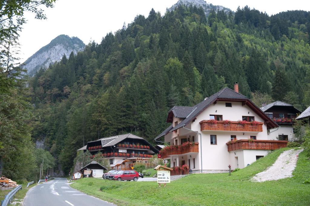 un bâtiment situé sur le côté d'une route à côté d'une montagne dans l'établissement Prenočišča Valentina, à Solčava