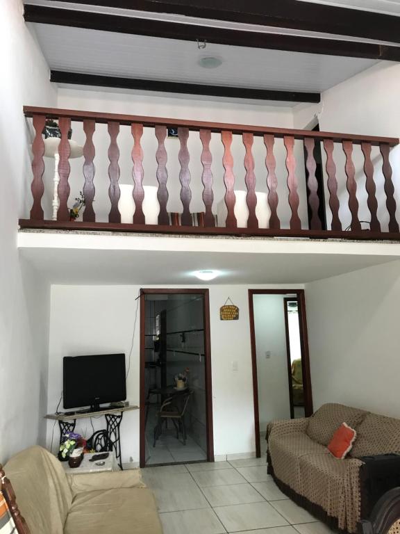 a living room with a staircase and a couch at Casa em condomínio com churrasqueira in Cabo Frio