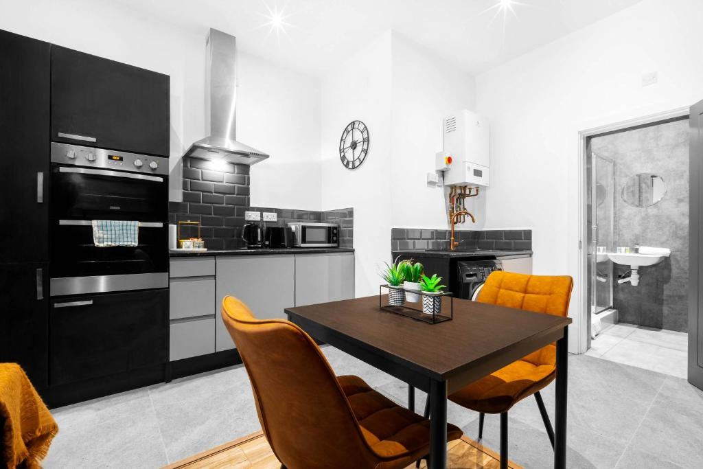kuchnia ze stołem i krzesłami w pokoju w obiekcie New Luxury Apartment - Parking - Netflix - Wifi - Apt 49G w mieście Sleightholme