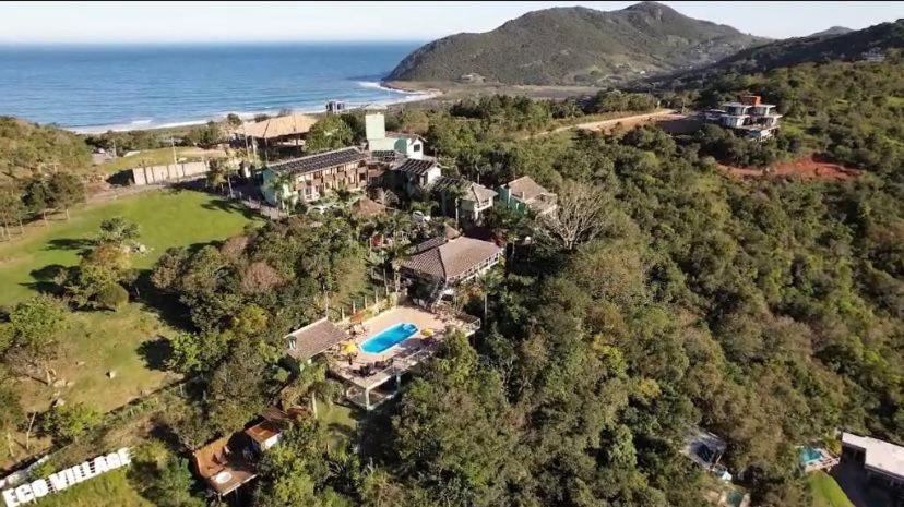 an aerial view of a house on a hill next to the ocean at Silveira Eco Village in Garopaba