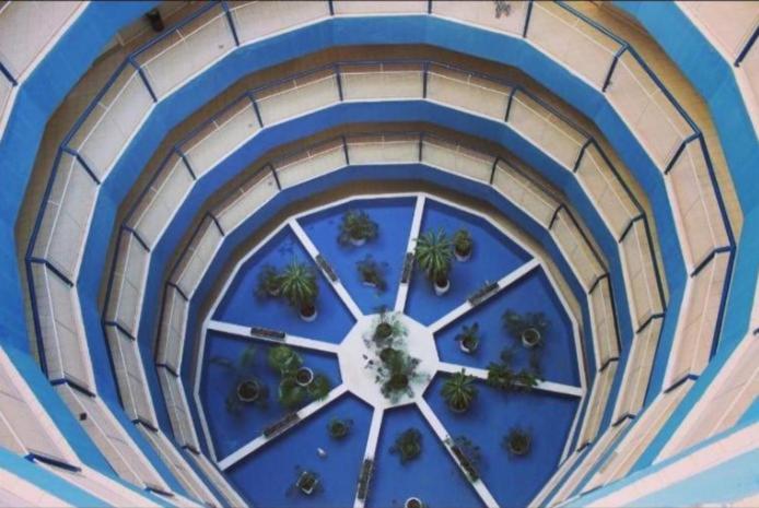 a clock on the top of a building with plants at Caldas Novas - Araras Apart Service in Caldas Novas