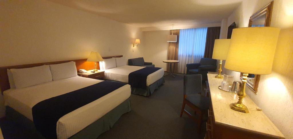 ein Hotelzimmer mit 2 Betten und einem Schreibtisch in der Unterkunft Hotel Bristol in Mexiko-Stadt