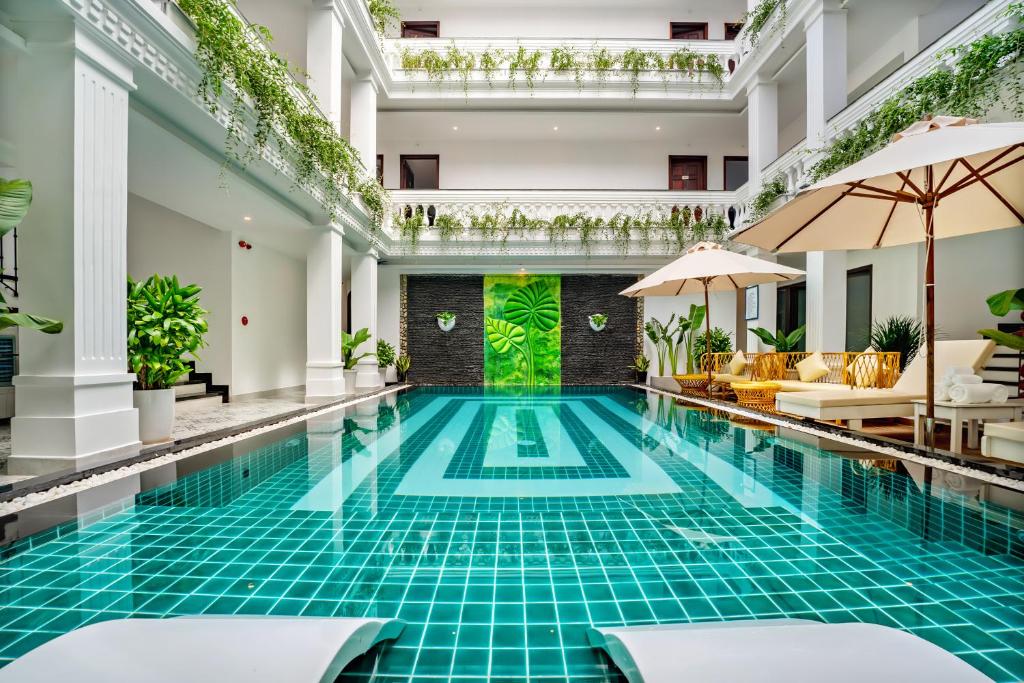 een zwembad met blauwe tegels in een hotellobby bij HA Royal Boutique Hotel in Hội An
