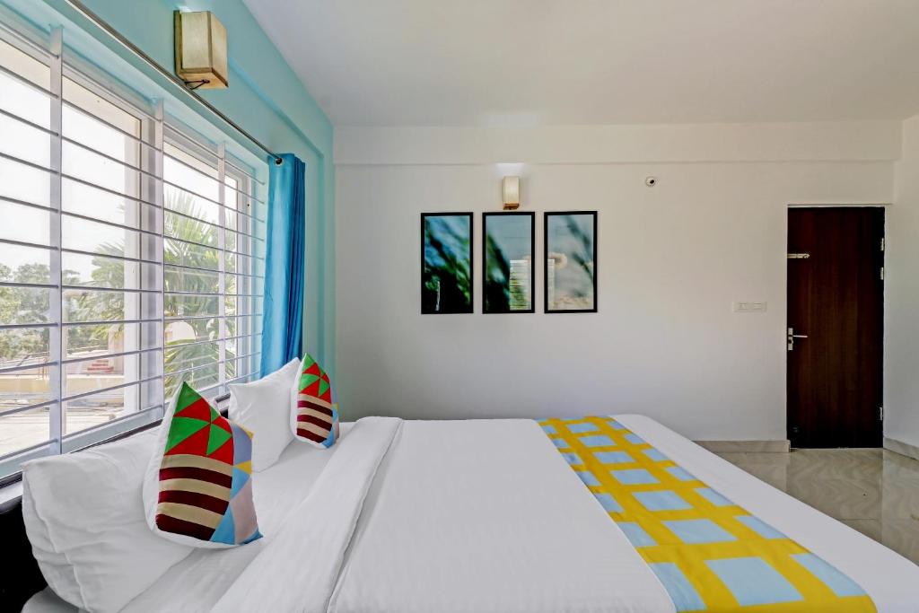 a bedroom with a large bed and a large window at OYO Nr Royal in Bangalore