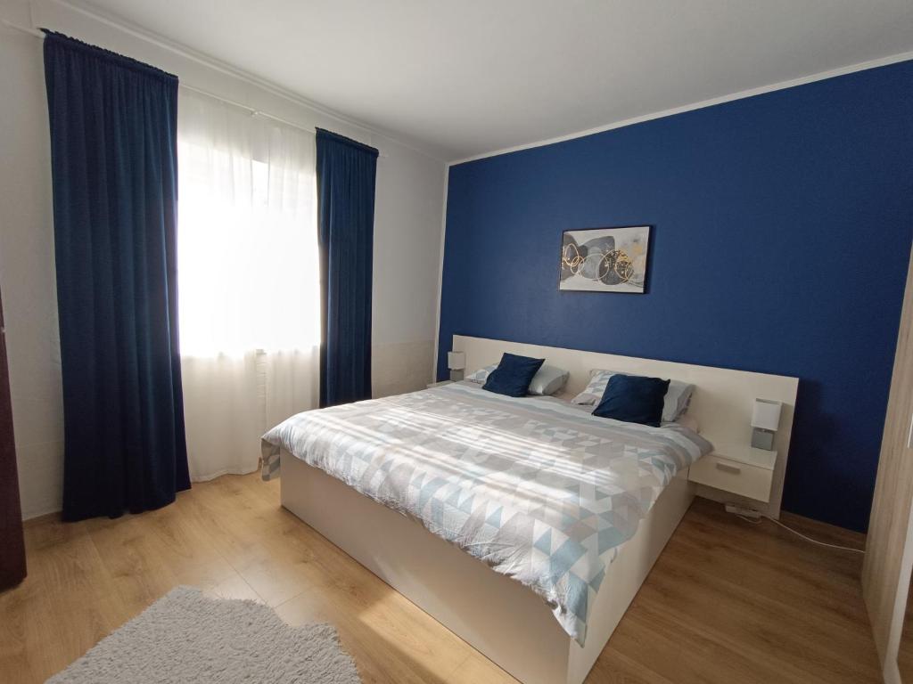 um quarto com uma cama com paredes azuis e uma janela em Apartment Dora em Zadar
