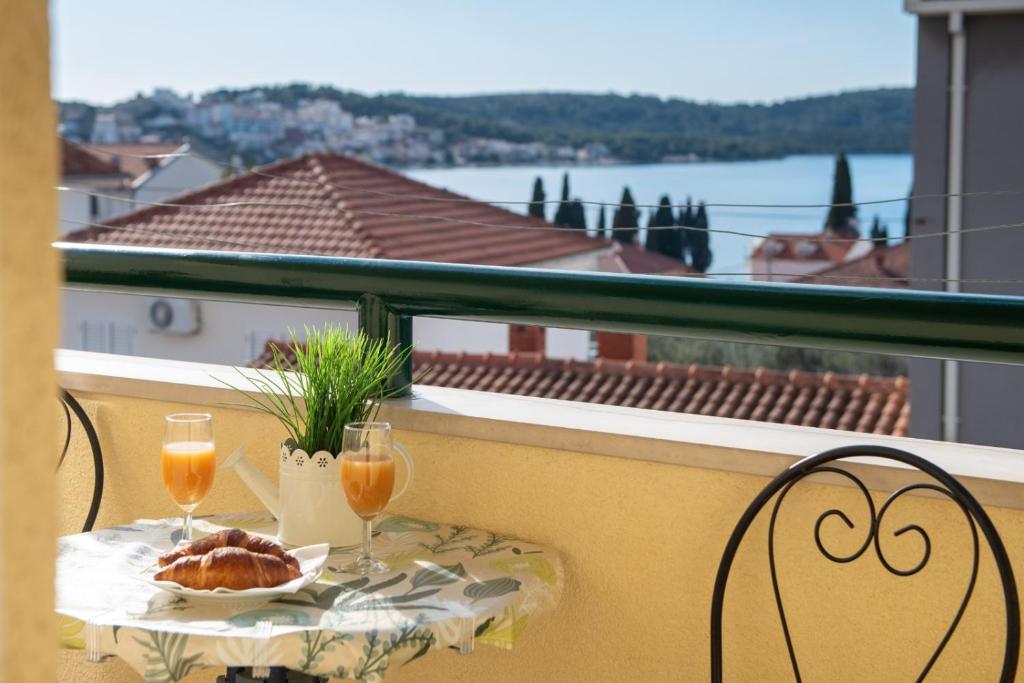 una mesa con un plato de pan y dos vasos de zumo de naranja en Apartment Anita, en Trogir