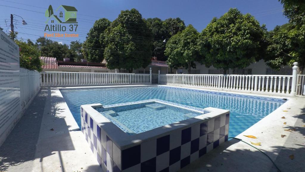 een zwembad in een achtertuin met een wit hek bij Melgar-Tolima-Apartaestudio in Melgar