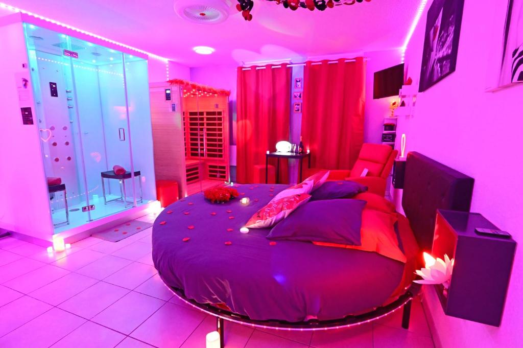 - une chambre rose avec un grand lit dans l'établissement Love Room à deux pas de l'Océan avec Hammam, Sauna et Bain à 2 Surprise garantie, à Biscarrosse