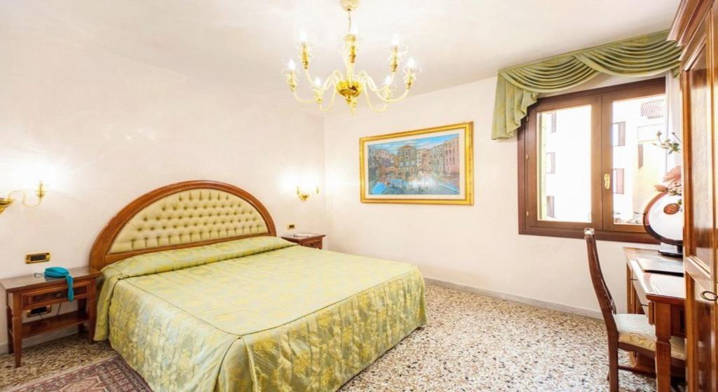 Schlafzimmer mit einem Bett und einem Kronleuchter in der Unterkunft Antica Casa Carettoni in Venedig