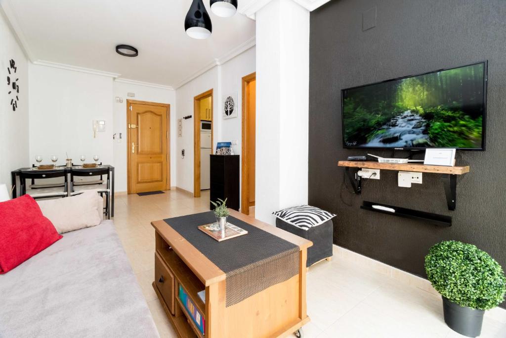 uma sala de estar com uma televisão de ecrã plano na parede em RELAX em Torrevieja