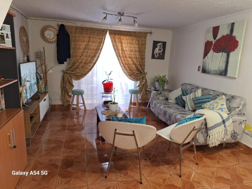 sala de estar con sofá, mesa y sillas en Familia Flores Sáez, en Parral
