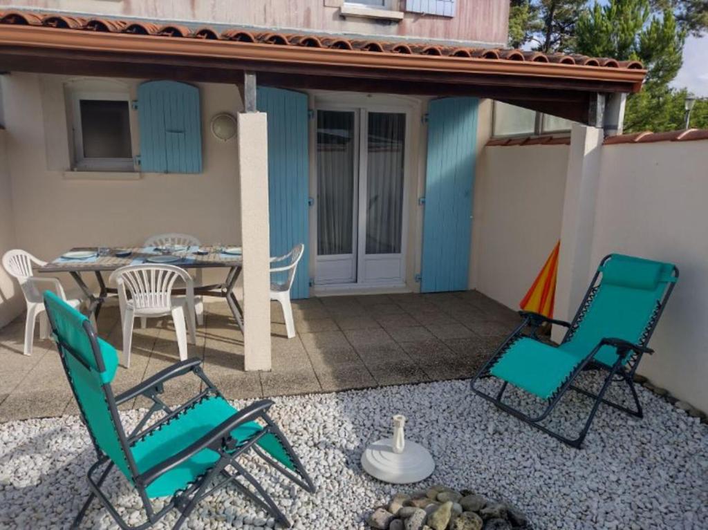 d'une terrasse avec des chaises, une table, une table et des chaises. dans l'établissement Séjour tranquille à Oléron, à Grand-Village-Plage