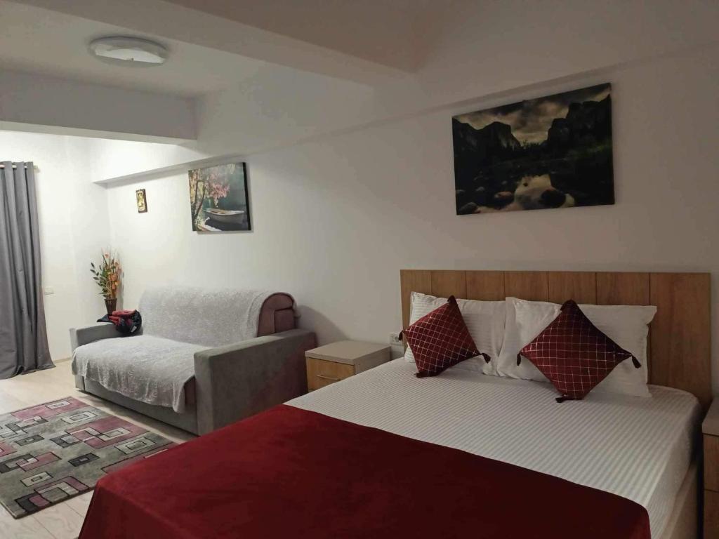 ein Hotelzimmer mit einem Bett und einem Sofa in der Unterkunft Studio Lavinia in Eforie Nord
