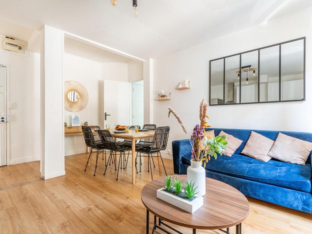 sala de estar con sofá azul y mesa en Michel Ange - Cosy appartement de 8P en París
