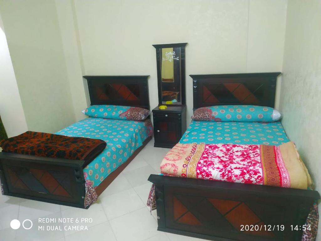 um quarto com 2 camas e uma cómoda em قرية النورس مكتب السعد em Ismaília
