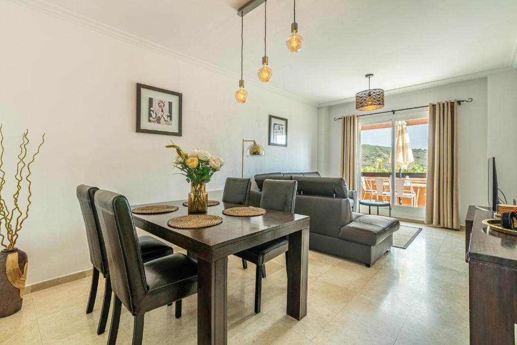 a living room with a dining room table and a couch at Casares del Sol Apartment in Casares