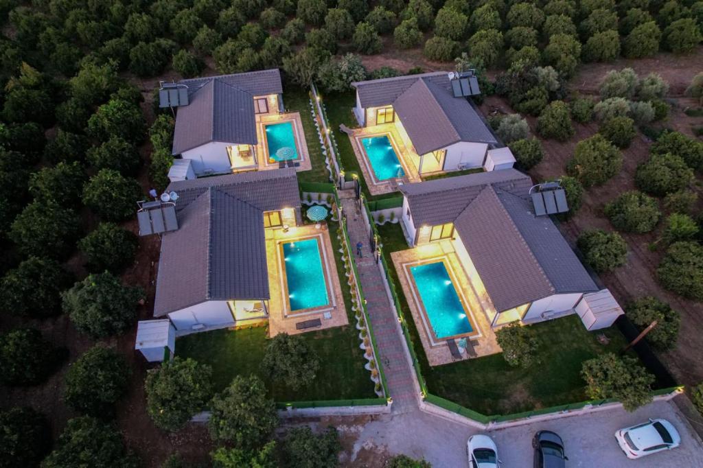 uma vista superior de uma grande casa com luzes azuis em MERA-12 FETHİYE KARGI HAVUZLU VİLLALARIMIZ em Fethiye