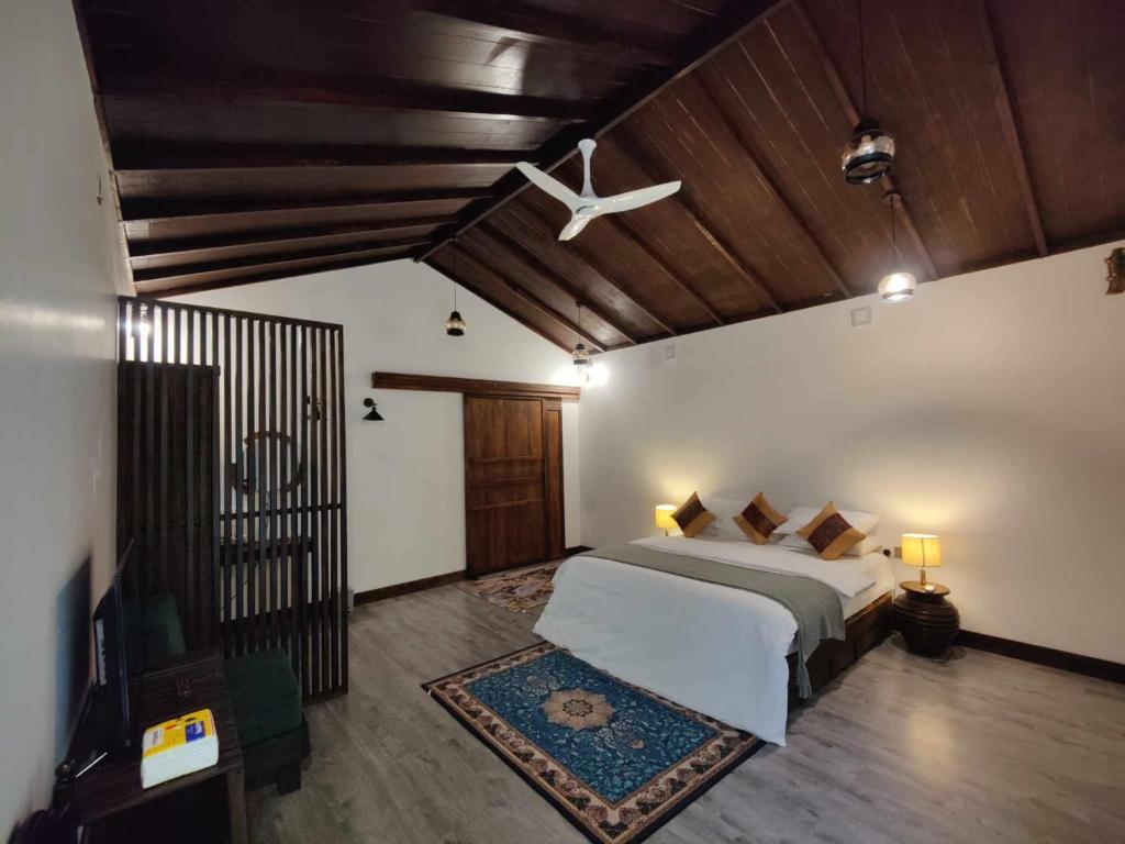 1 dormitorio con 1 cama y ventilador de techo en Private Villa by Rashuthere, en Rasdu