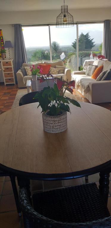 una sala de estar con una mesa de madera con plantas. en chambre avec vue sur les marais salants en Guérande